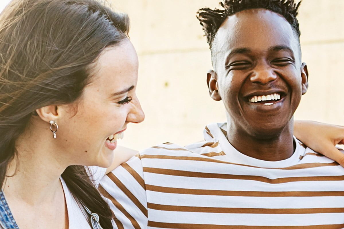 Twee personen lachend in de camera.