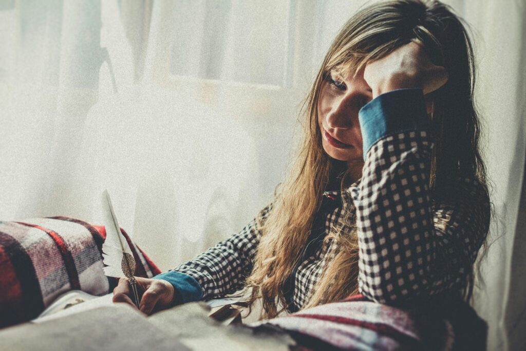 vrouw die met haar handen in het haar zit en waarschijnlijk veel stress heeft