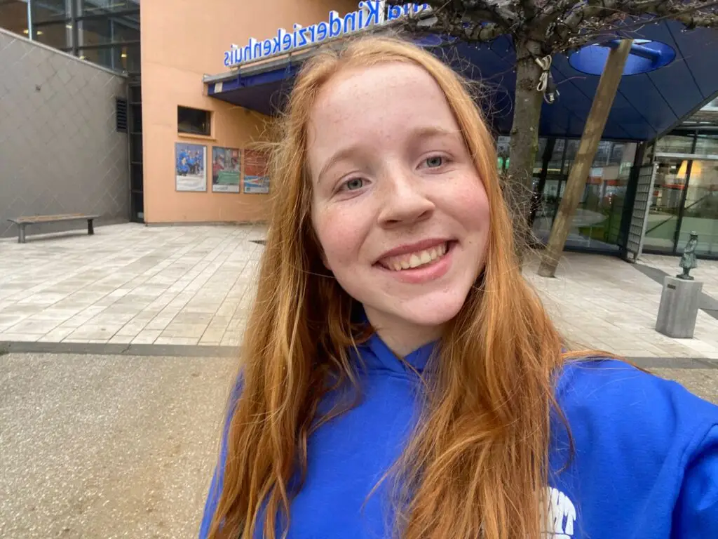 Merel lachend voor het Wilhelmina Kinderziekenhuis