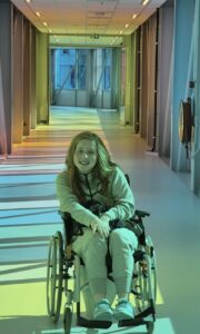Merel lachend in een rolstoel
