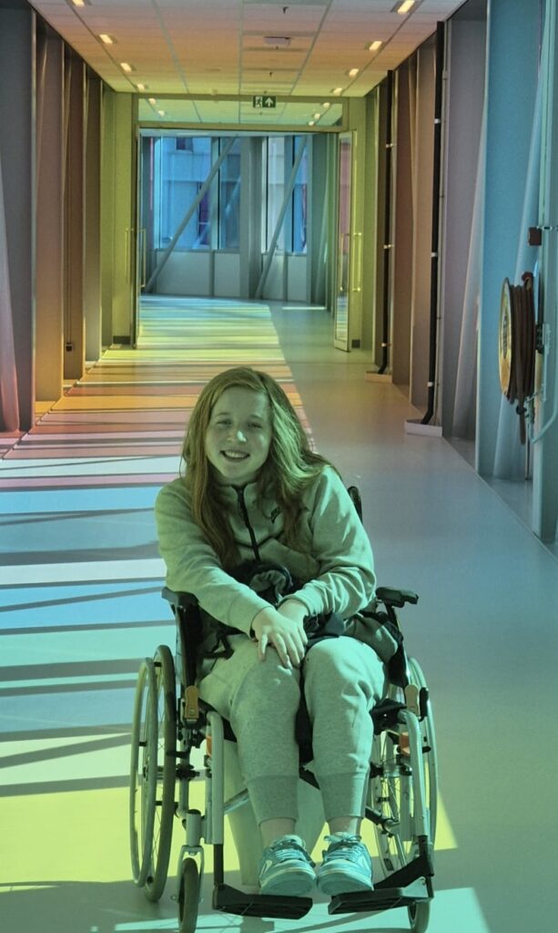 Merel lachend in een rolstoel